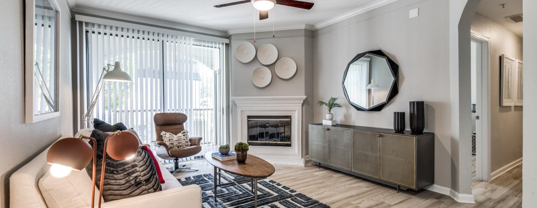 a living room with a fireplace and ceiling fan