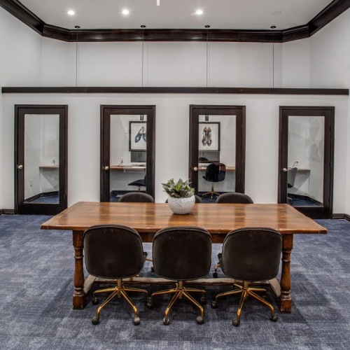 a room with a table chairs and private offices