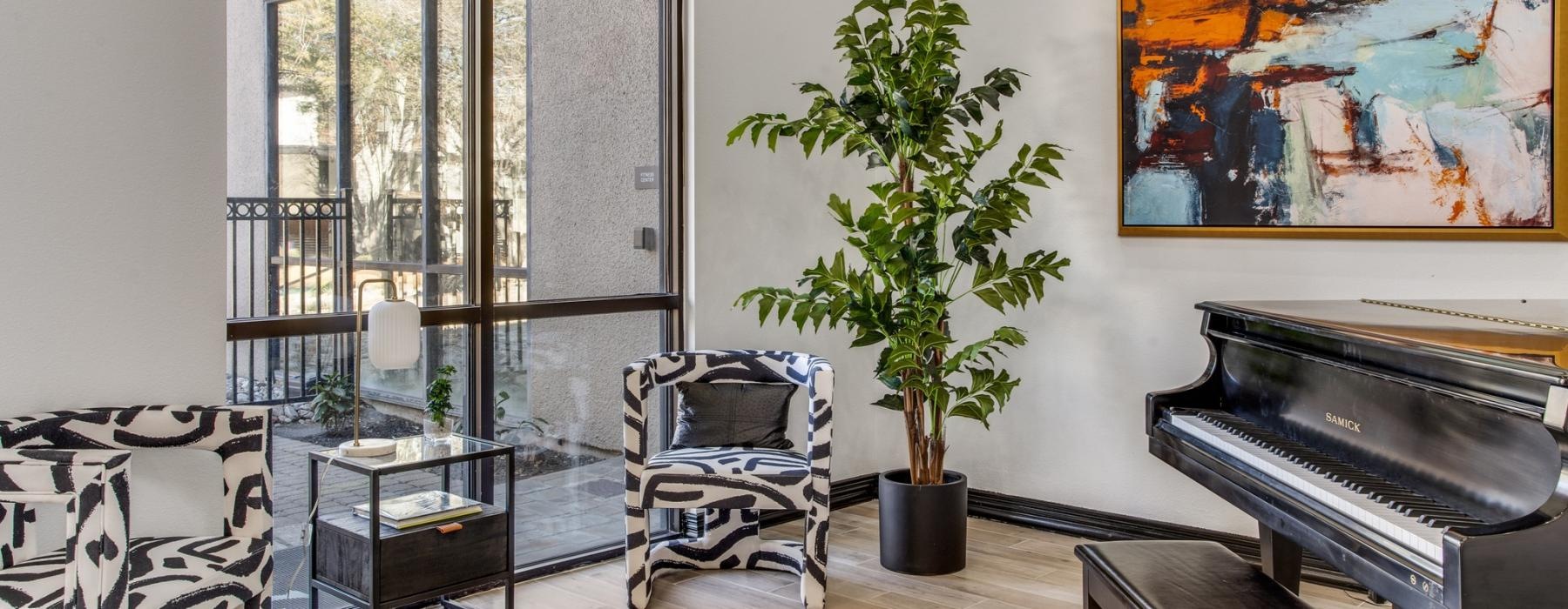 a room with a seating piano and a plant