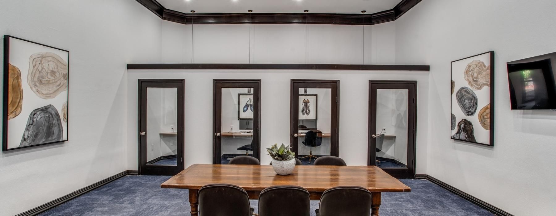 a room with a table chairs and private offices