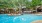 a swimming pool with trees and a building in the background